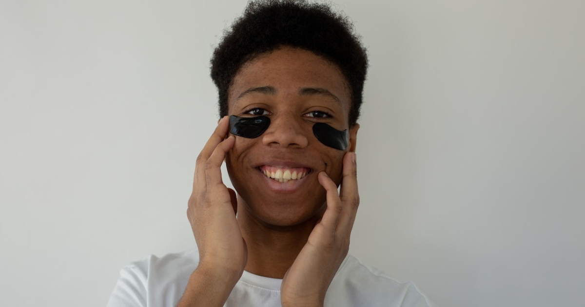 A teenager practicing self-care by relaxing and doing some skincare.