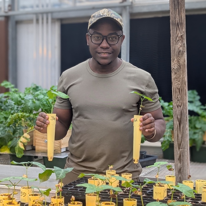 Shem Elias in a greenhouse posing with his latest experiment.