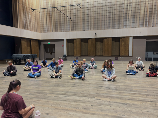 Students practicing wellness breathing in a music studio