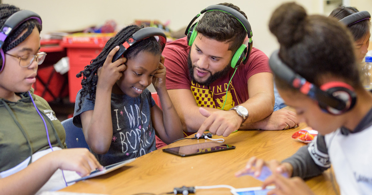 Danny Pineyro undergraduate music education majors in the College of Arts and Sciences volunteering with kids at Girls Inc. as part of the "Beat Goes On" - a summer program