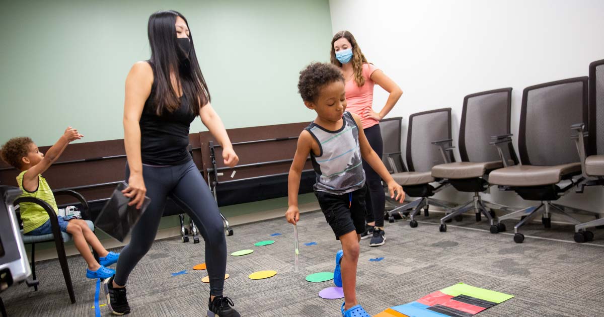 Two women practice athletics games with two kids
