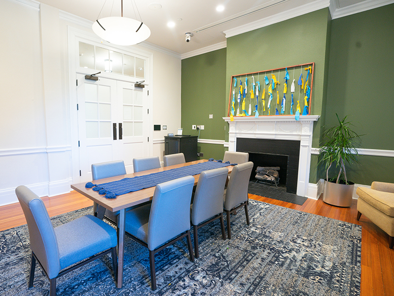 Warner Hall Room 102: room with a fireplace and chairs arranged around a rectangular table