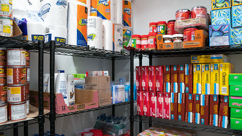 Stocked shelves of food and toiletries in the Food and Supply Pantry