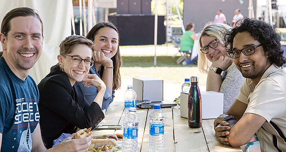 People sitting together at picnic table smiling