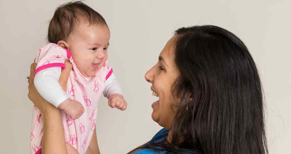 Woman holding up smiling baby