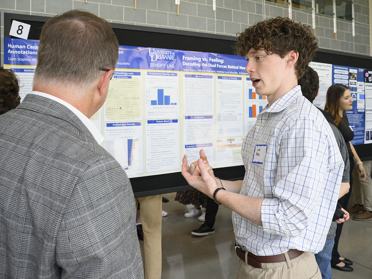 A young student explains research to an onlooker