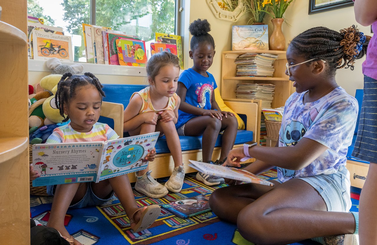 Student working with children on reading skills.