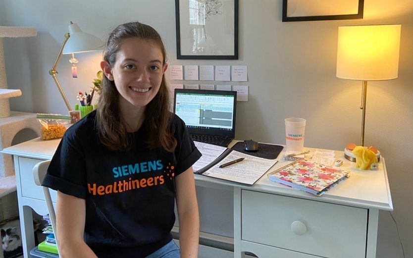 Christina LeFebvre smiles as she sits at her desk for her remote internship