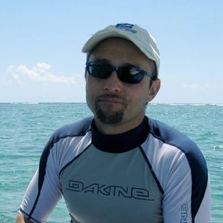 photo of Mark Warner in sunglasses in front of blue water and sky