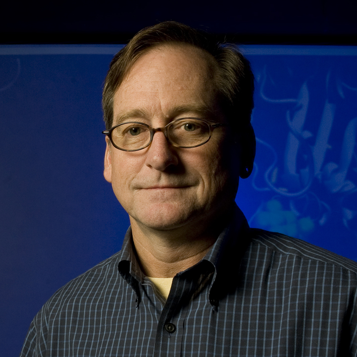 Adam Marsh in DBI, stands in front of a molecule protein model.