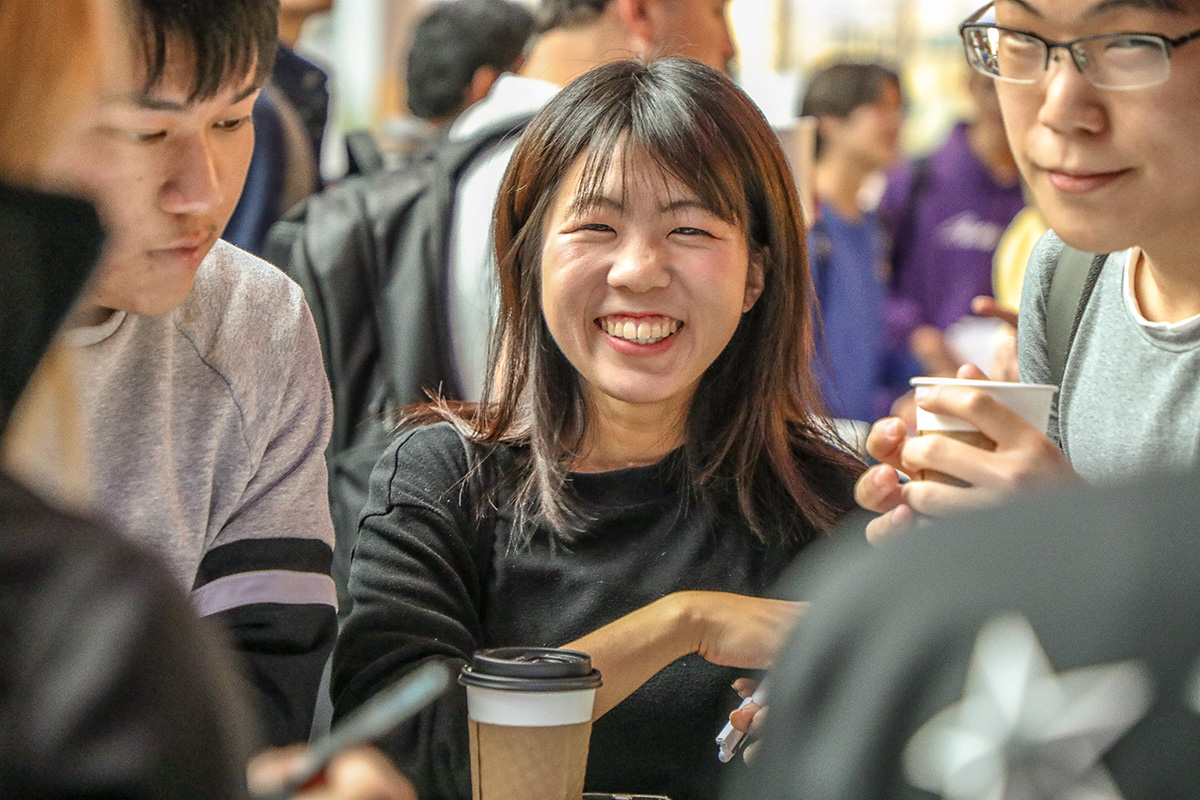 Smiling and laughing students at an OISS coffee hour.