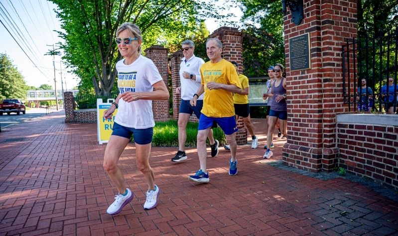President Laura Carlson running with staff and students