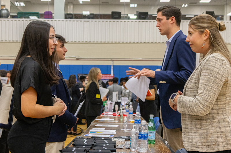 students talk to employers at a career fair