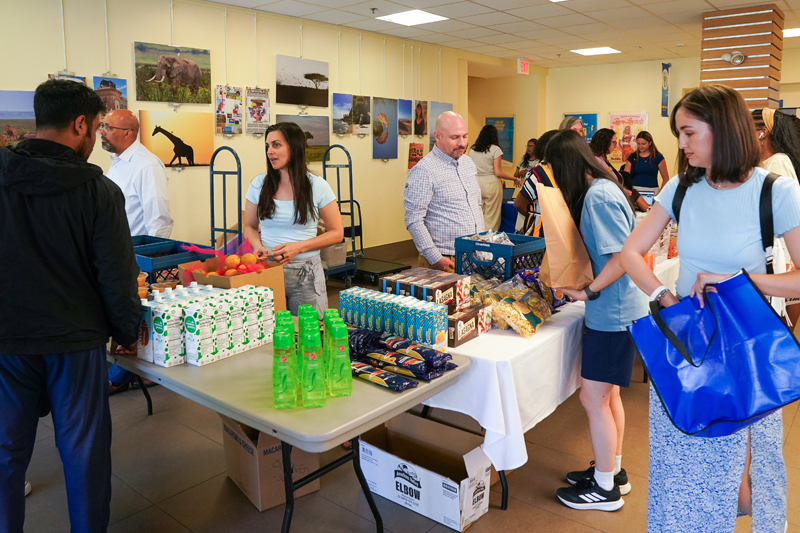 students shop while staff work at one of SDI's MiniMarkets