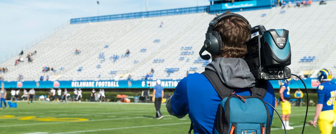 Photo of videographer filming a football game