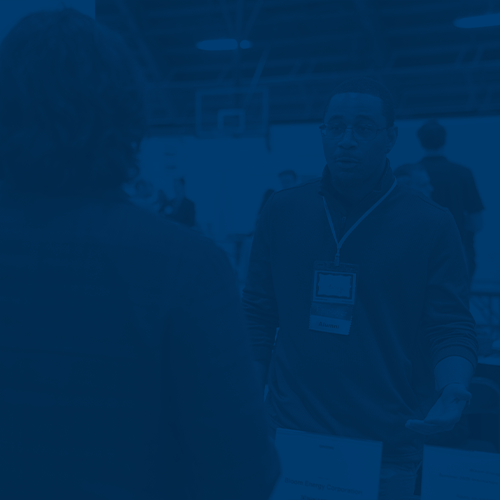Employer speaks with student at a Career Fair