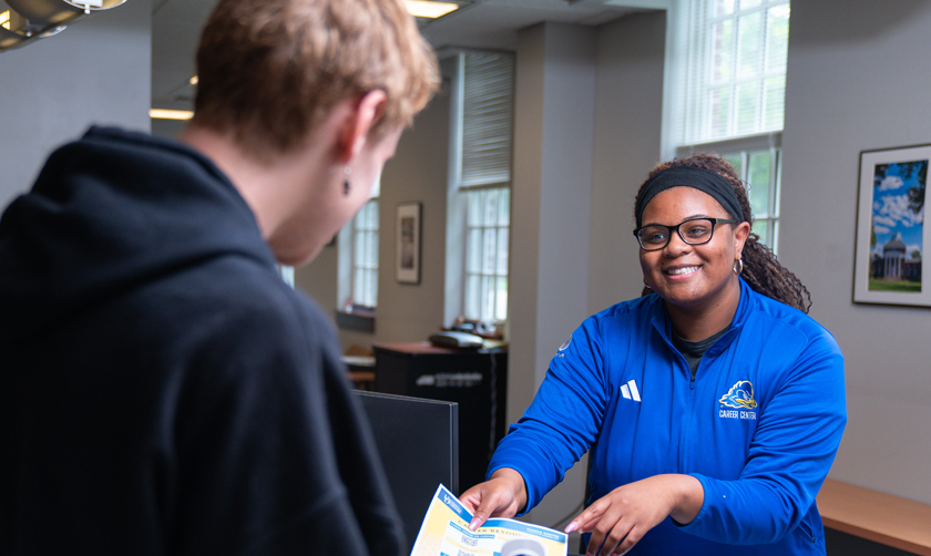 a student employee at Career Center's front desk assists a visiting student