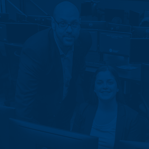 Student and faculty working in the Michael and Rosann Geltzeiler Trading Center
