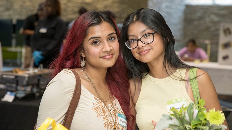 1743-Welcome_Days-SDI-Welcome_Reception-ME-082822 Two female students at the SDI Welcome Reception