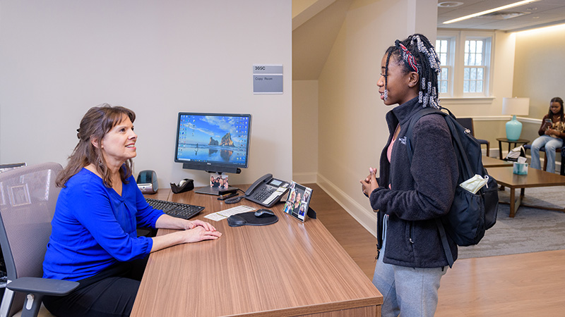 A female students visits the Student Wellness and Health Promotion front desk