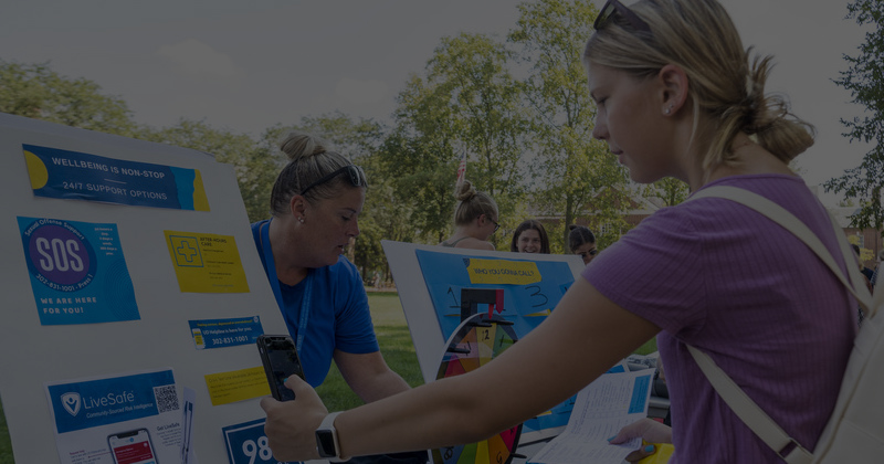 a student visits a table at a Wellness Fair
