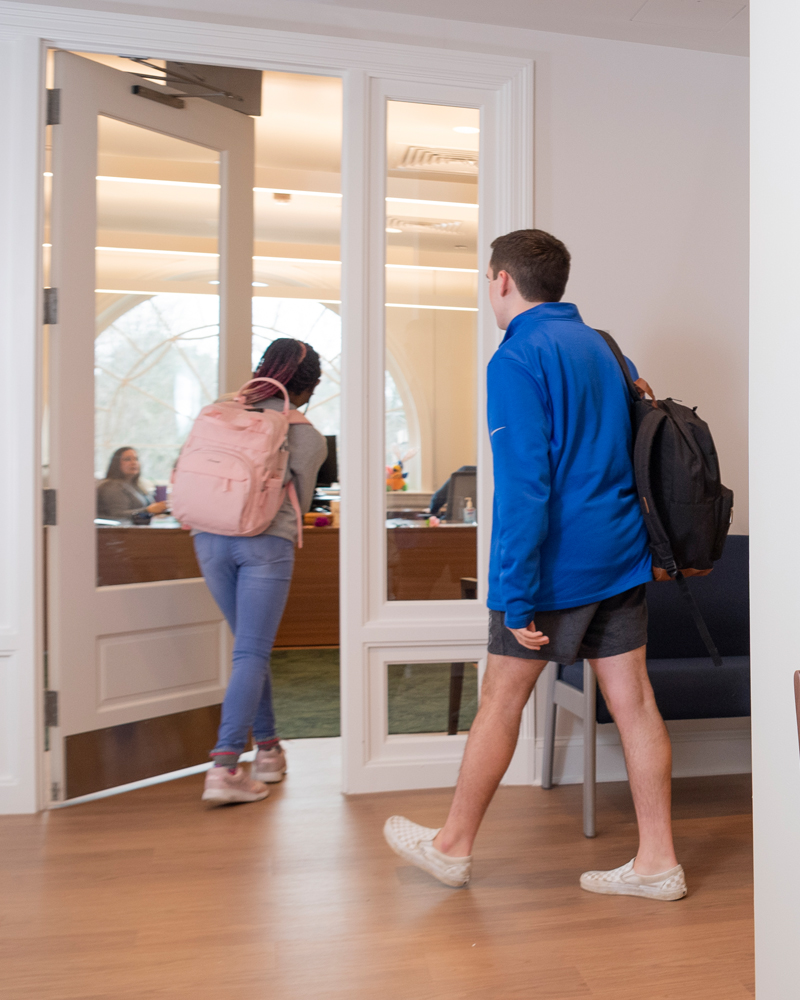two students enter into a reception area in Warner Hall