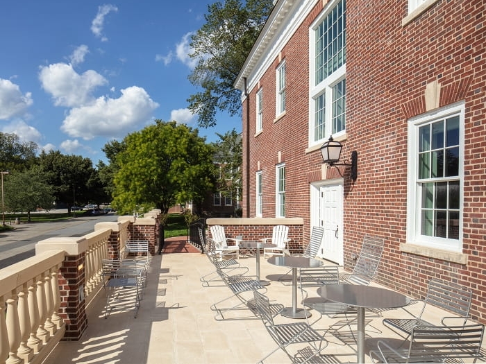 Warner Hall Patio: open air patio area with small round tables and outdoor chairs