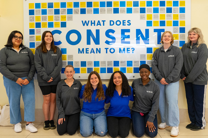 a group of students poses in front of the Consent Art Installation in Perkins