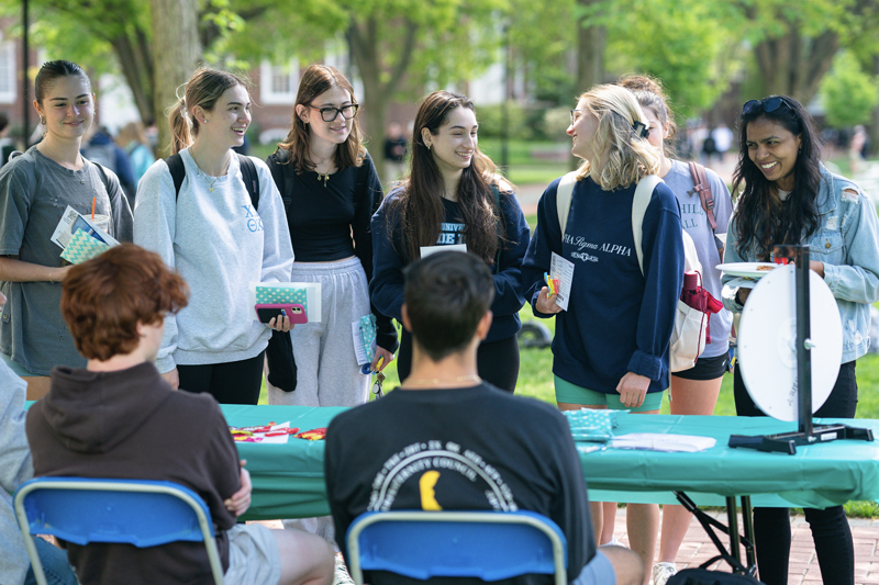 a group of students learns information at a table at the Support Fair