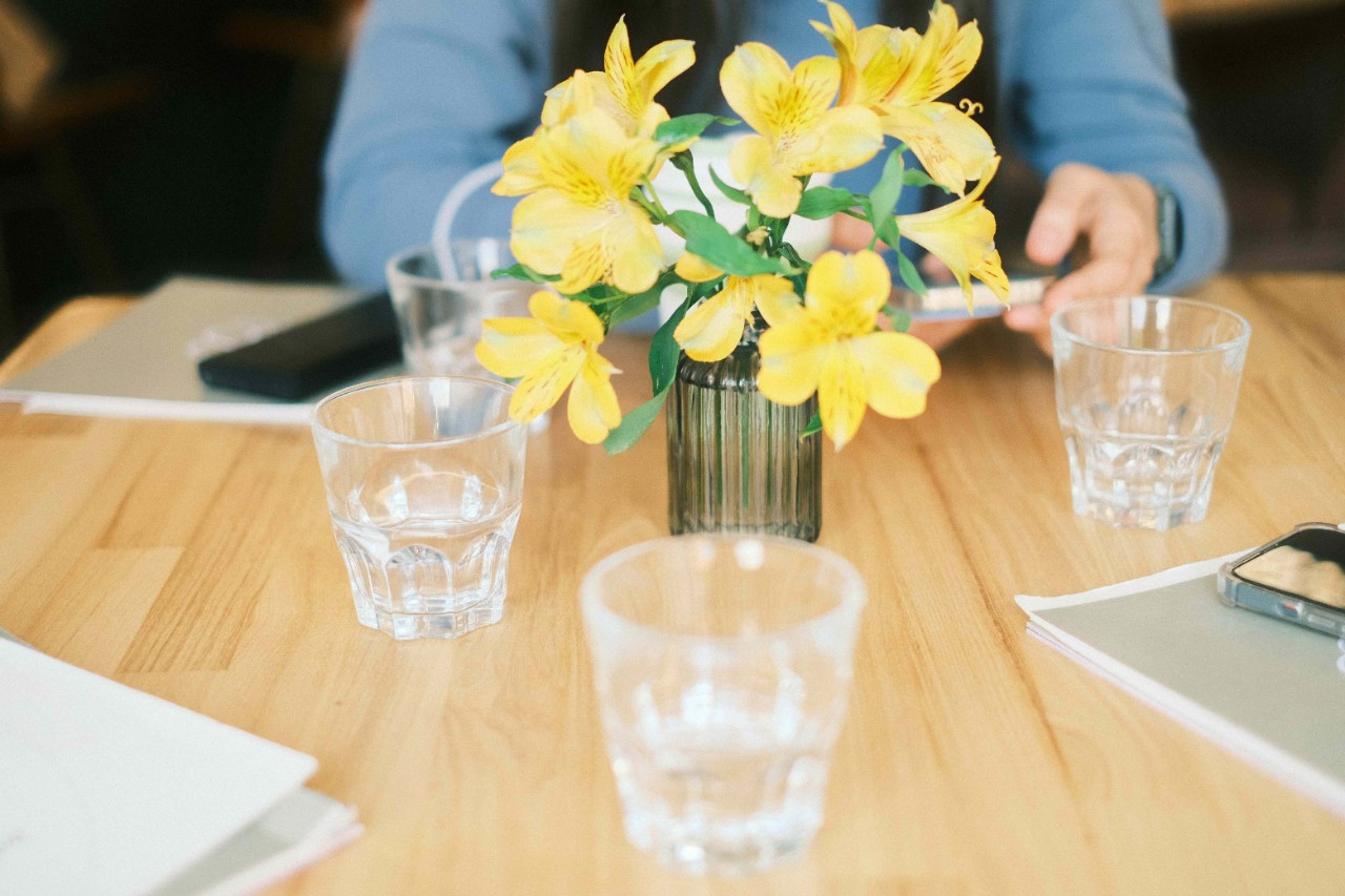 Student at table with water glasses and flowers