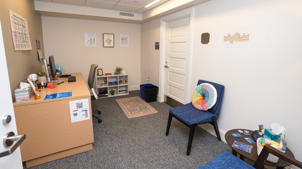 an extern's office in CCSD showing a desk and chairs, as well as a door on the far wall.