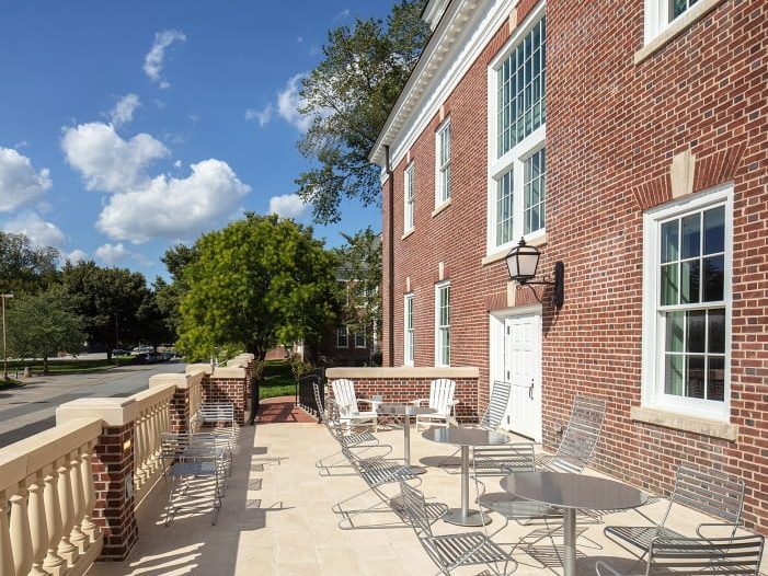 Open air patio area with small round tables and outdoor chairs