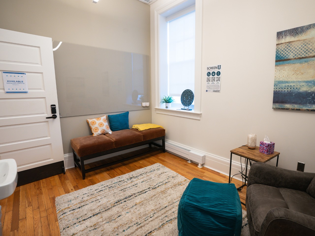 Small meeting room with rectangular table, chairs and glass writing board