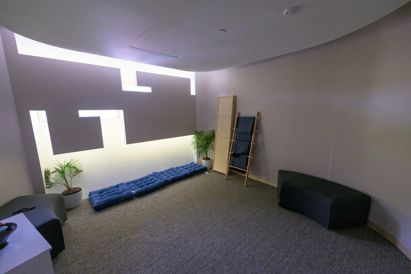 Interior of Interfaith Meditation and Prayer Room with pillows, decorative plants, seating and a privacy divider
