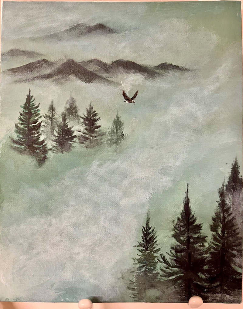 Acrylic painting of an eagle flying in the clouds, above the woods, with rolling mountains in the distance.