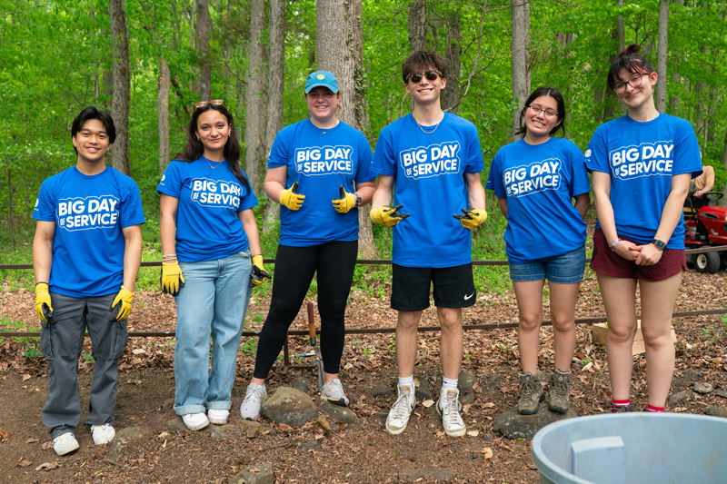 six students pause their clean-up work in woods at White Clay Creek State Park to pose for a picture.