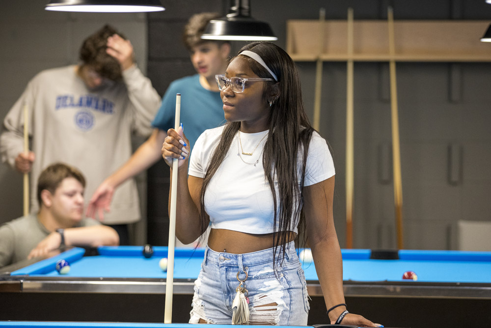 Students play pool in the Hen Zone