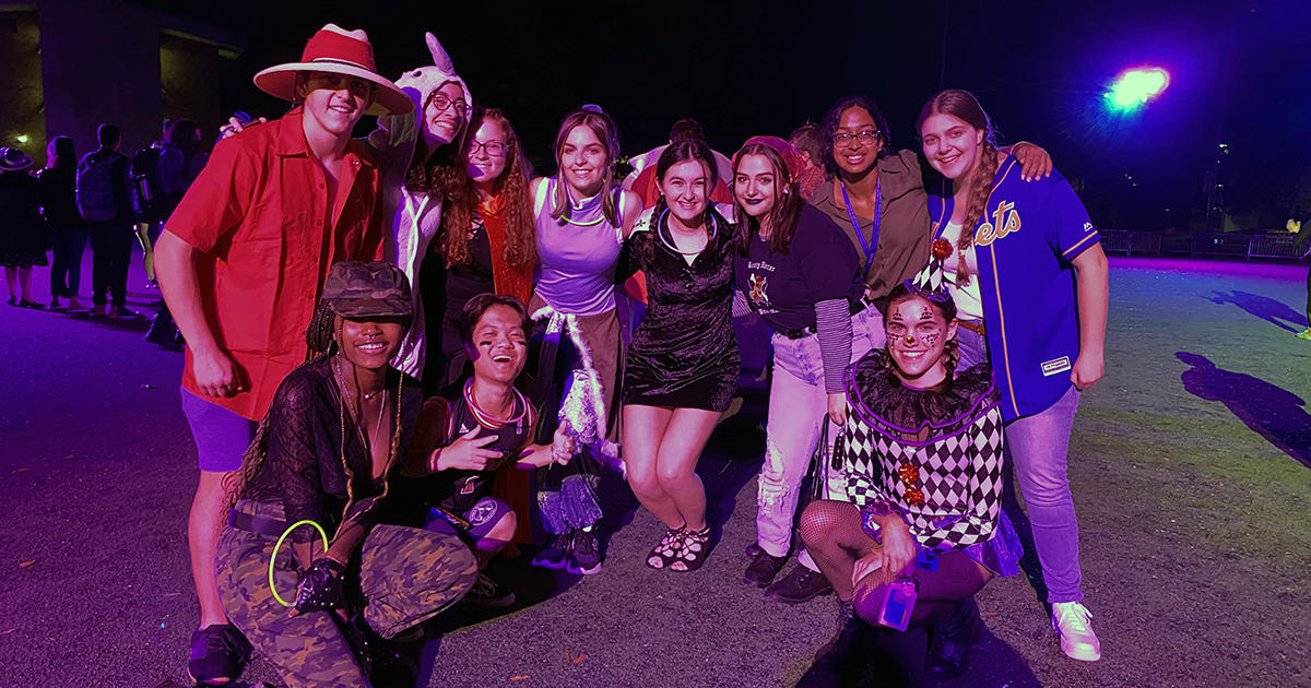 Group of students pose in costume on campus