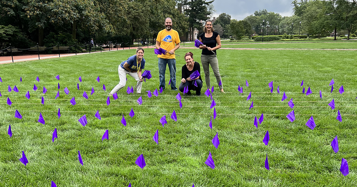 CSCR staff pose among purple flags on The Green in honor of National Recovery Month