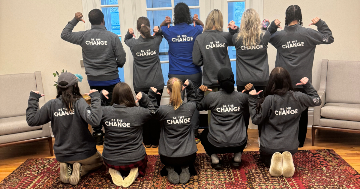 Blue Hens CARE Peer Educators pose with backs of t-shirts that read "Be the Change"