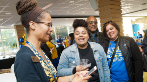 Student Life staff talking and laughing with a family