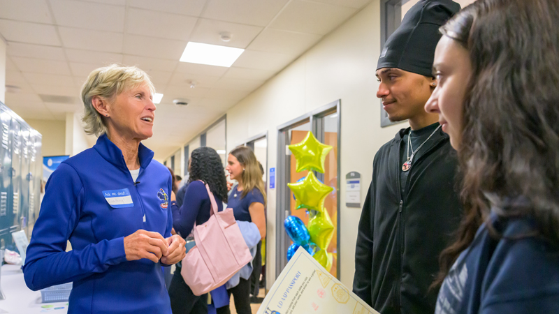 a staff member talks with two students at AAP orientation.