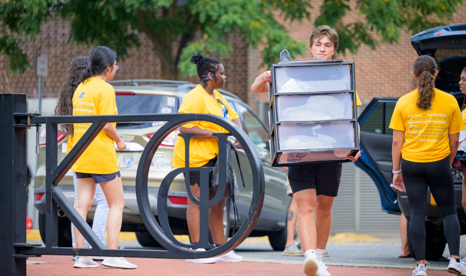 Students unloading furniture from cars