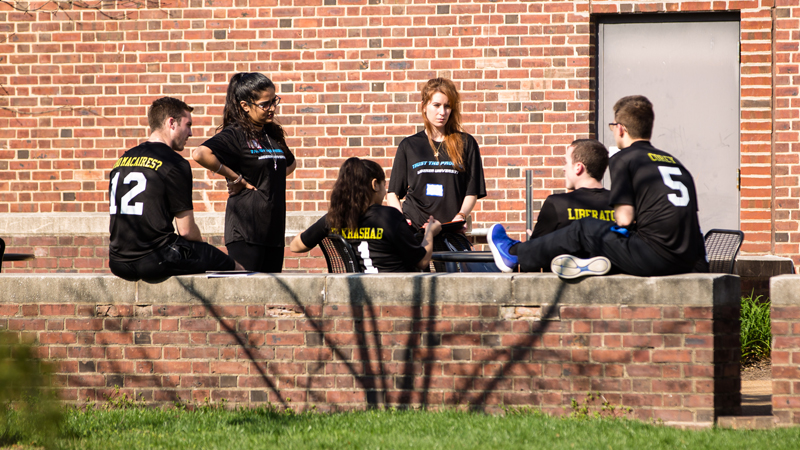 a group sits outside and discusses a project as part of the Horn Program.
