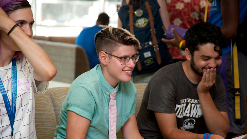 three UD students sit on a couch participating in a game.