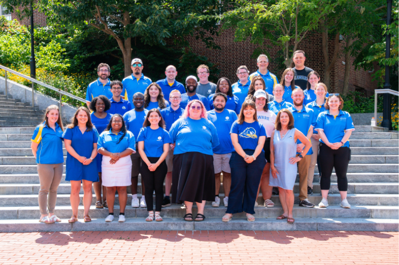 Join Our Team Page Photos - 1 Residence Life and Housing staff standing outside on the steps of Caesar Rodney