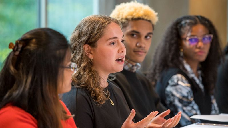 Group of students standing around a table at the First-Generation Day Lunch