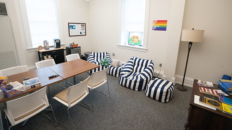 Collegiate Recovery Community space with comfortable seating, a table with chairs, books and games