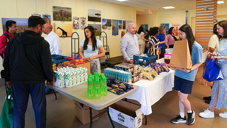 Staff assist students with food selections at a Mini Market event in Perkins