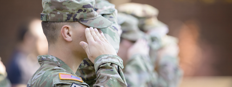 a row of students in military uniforms salute